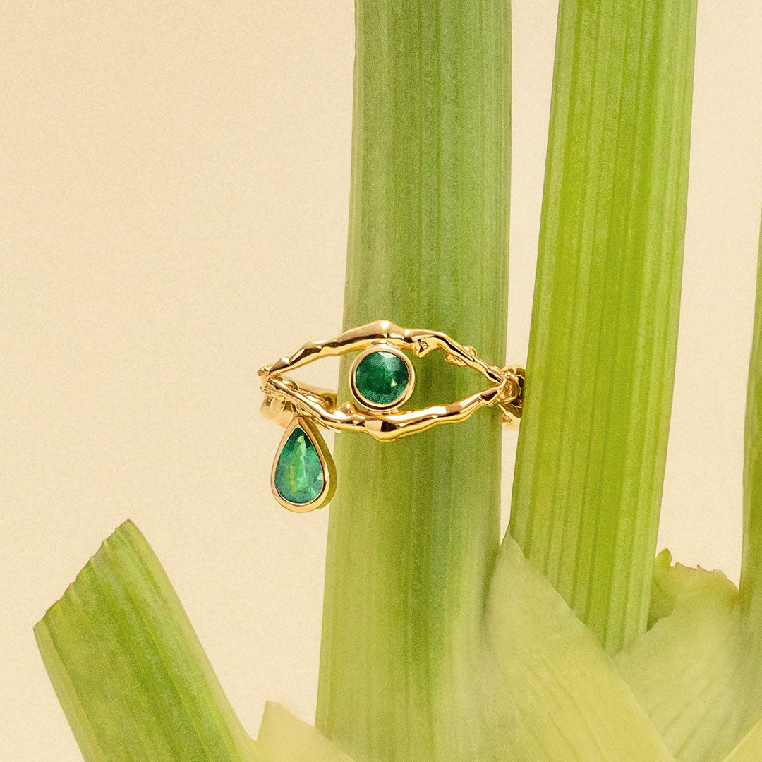 18k gold eye ring with tear adorned with emeralds
