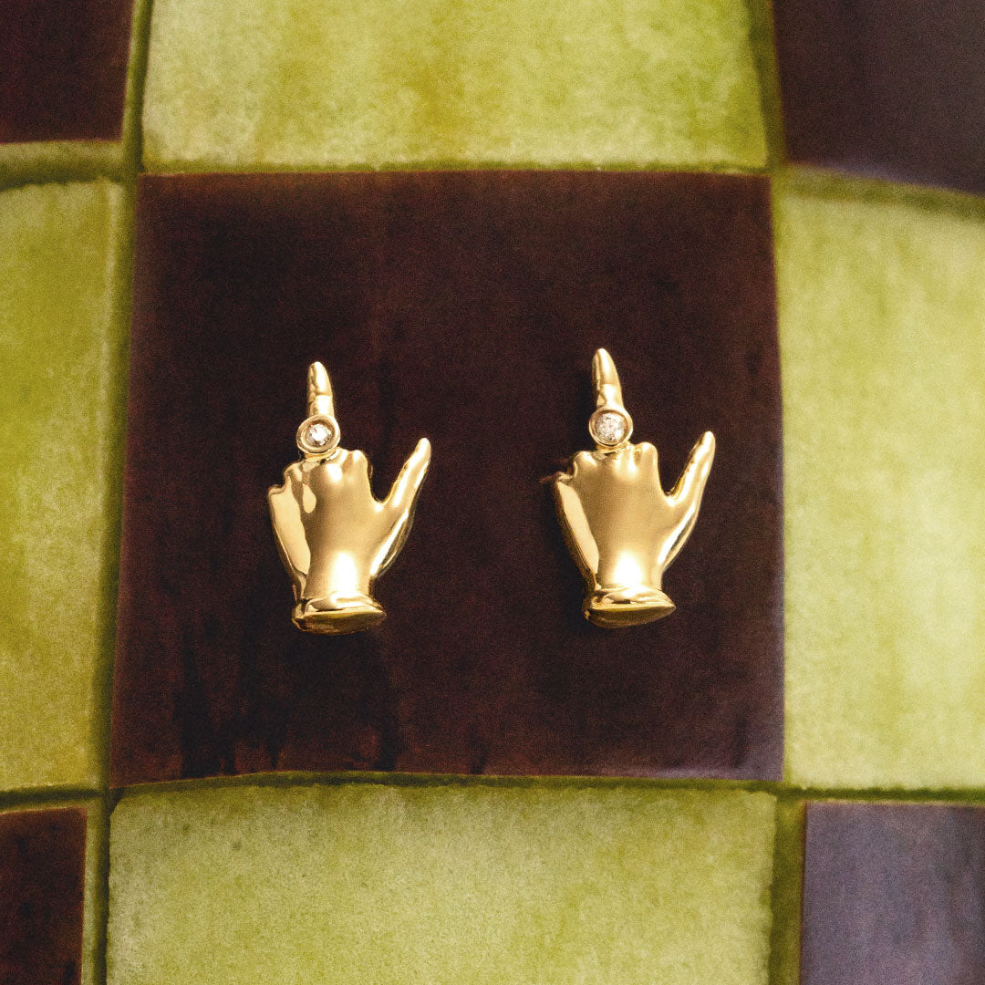 18k gold middle finger earrings adorned with diamonds