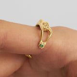 Model wearing an 18k gold and emerald ring of a female body