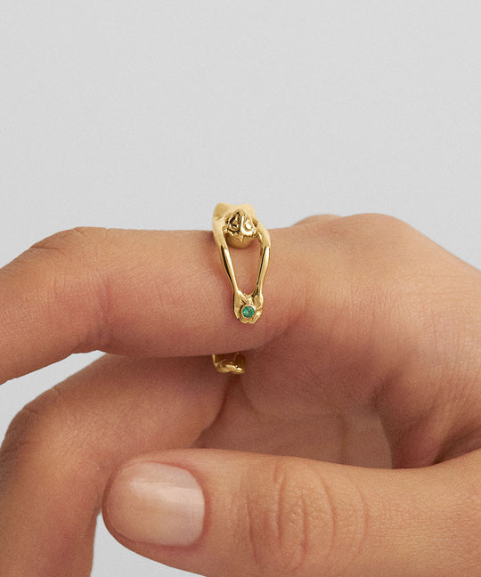 Model wearing an 18k gold and emerald jewelry piece in the form of a female body ring