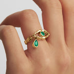Model wearing eye ring with tear and bodies in 18k gold and emeralds