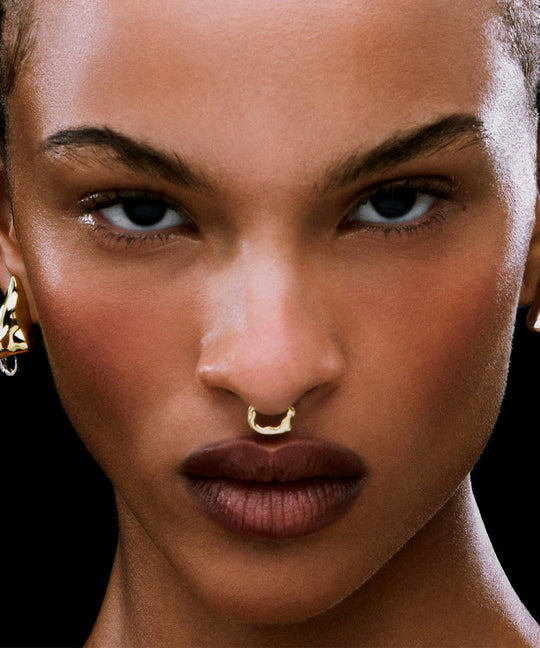 Model wearing a clip-on piercing in sterling silver with 18k gold plating of a female body