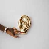 Model with a brass ear sculpture