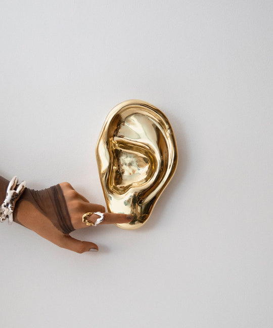 Model with a brass ear sculpture