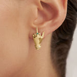 Model wearing sterling silver middle finger earring with 18k gold plating and emerald
