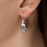 Model wearing a palm-shaped earring in sterling silver