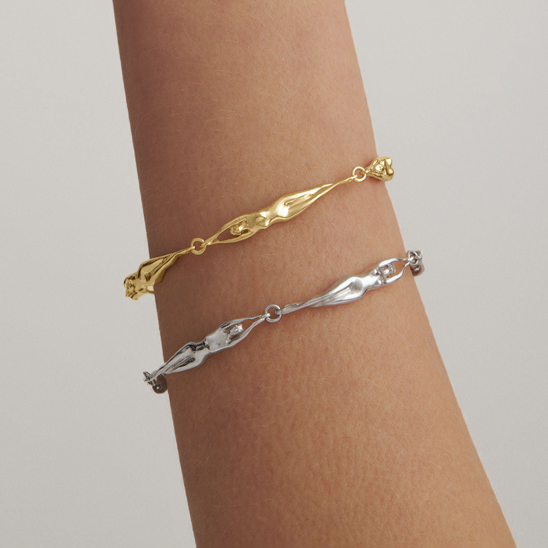 Model wearing a chain bracelet with female bodies in sterling silver with 18k gold plating