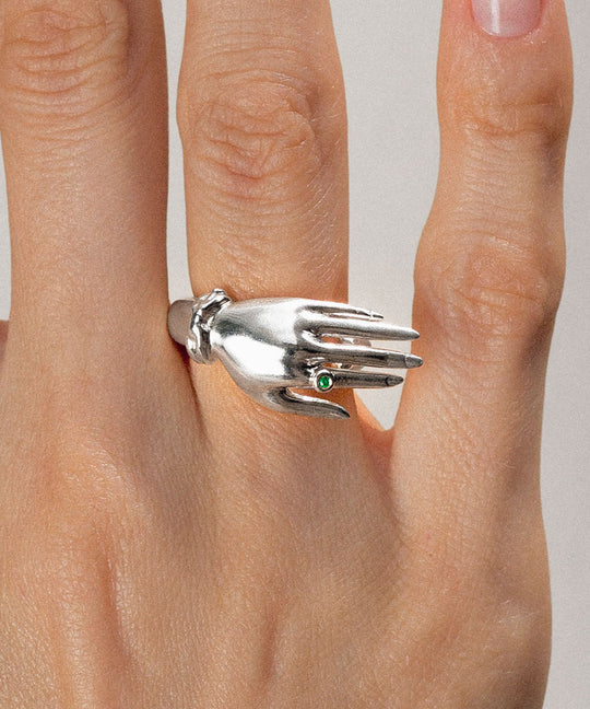 Model wearing a sterling silver hand ring with an emerald