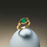 18k gold ring of hands with diamonds and oval emerald